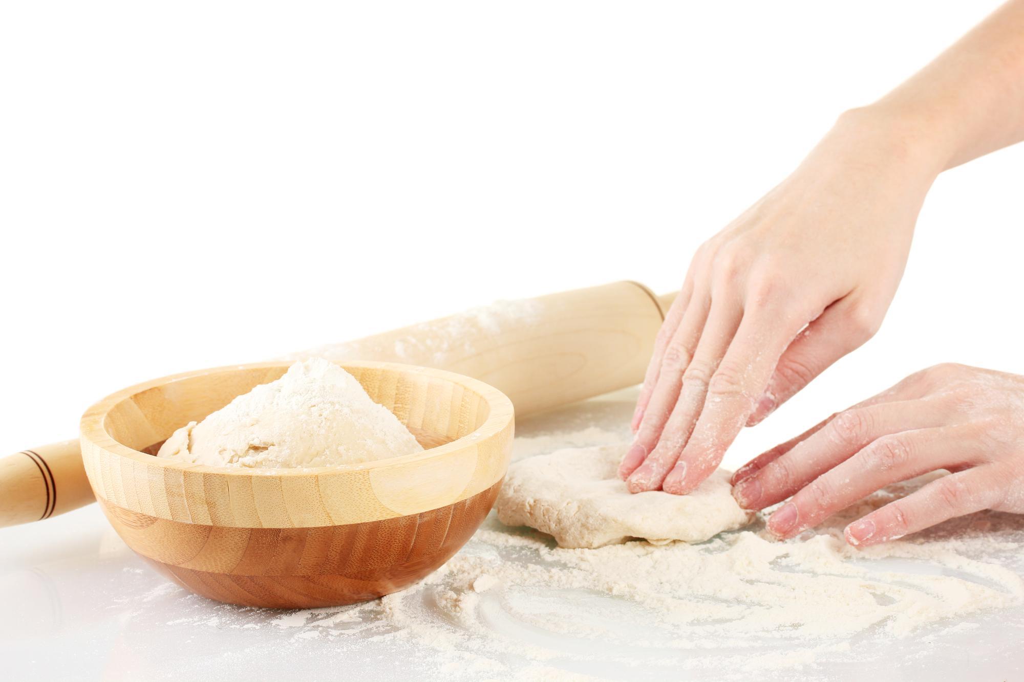 Hands shaping dough in workshop